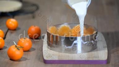 烹调橙汁慕斯蛋糕的过程。往糕点圈里倒慕斯